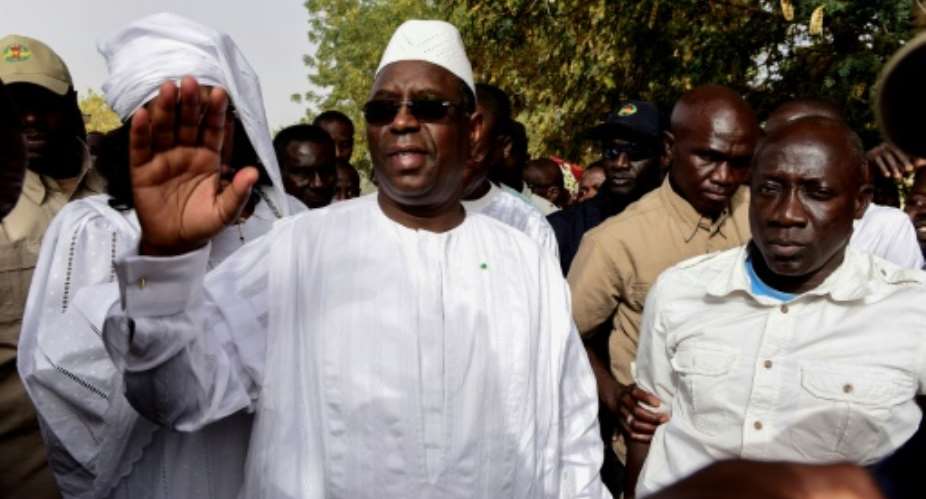 Incumbent President Macky Sall C is expected to win enough votes to claim a first-round victory, according to local media reports of regional vote tallies.  By SEYLLOU AFP