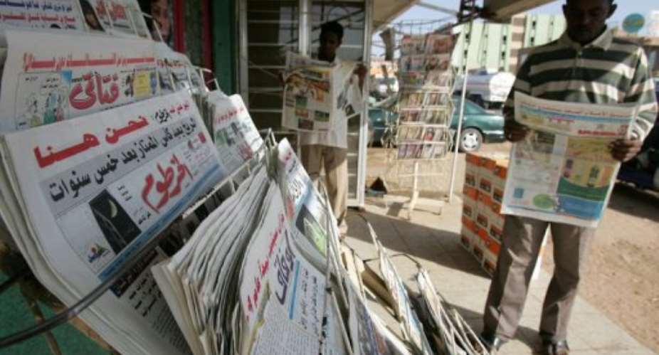 Sudanese men read newspapers in Khartoum.  By Ashraf Shazly AFPFile