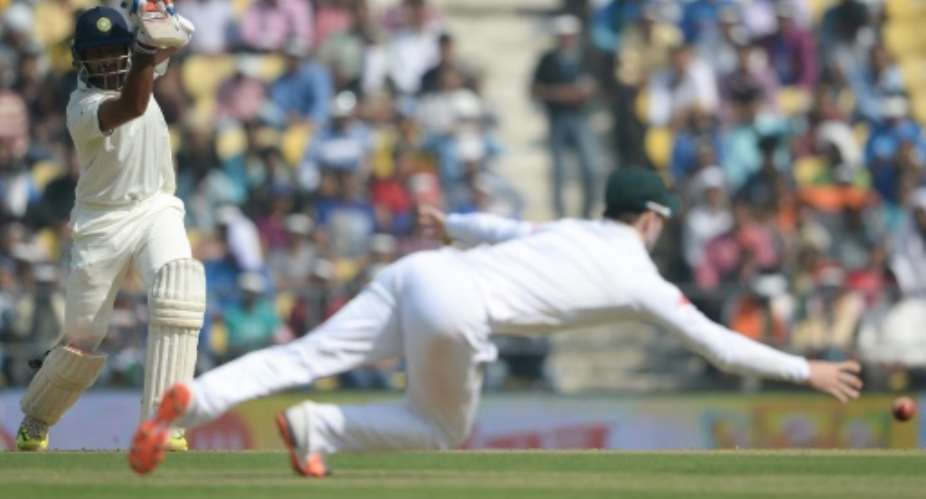 South Africa's AB de Villiers dives to stop a shot by India's Cheteshwar Pujara during play on the first day of the third Test in Nagpur on November 25, 2015.  By Indranil Mukherjee AFP