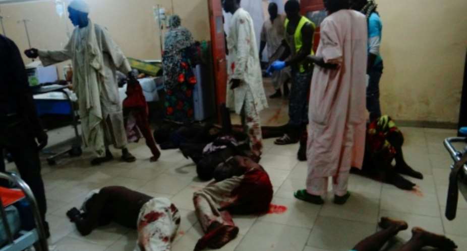 Injured victims of a female suicide bomber lie on the floor awaiting medical attention as beds were no longer available at a Maiduguri hospital in northeastern Nigeria.  By  AFP