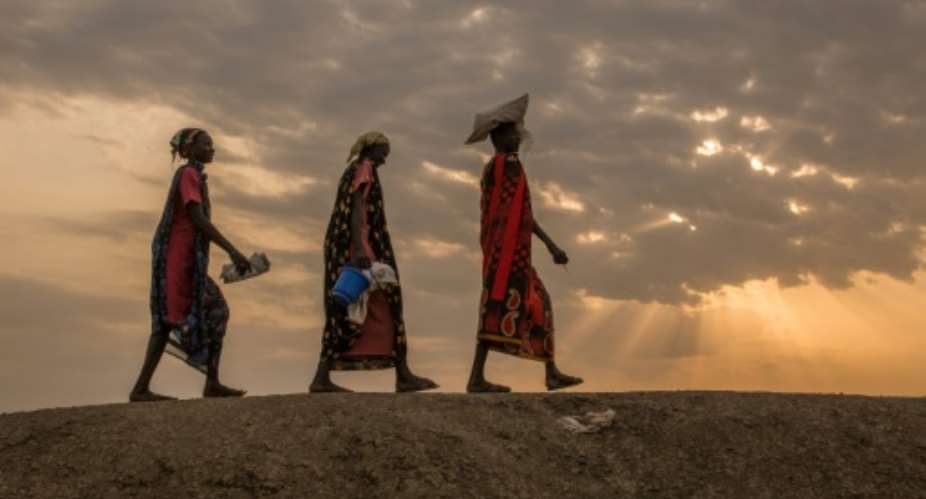 Internally displaced women walk to an early morning food distribution in Bentiu, South Sudan, a country where millions have been uprooted and tens of thousands killed during a civil war.  By Stefanie GLINSKI AFPFile