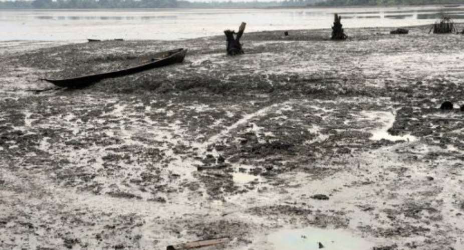 A fishing boat is abandoned in a Bodo waterway polluted by spilled crude oil.  By Pius Utomi Ekpei AFPFile