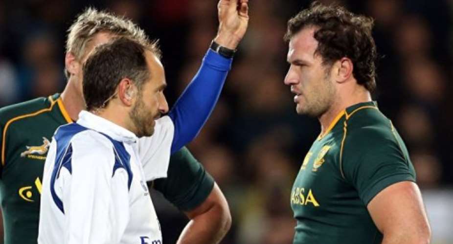 Bismarck du Plessis of South Africa (R) is yellow-carded by referee Romain Poite (L) in Auckland on September 14, 2013.  By Michael Bradley (AFP/File)