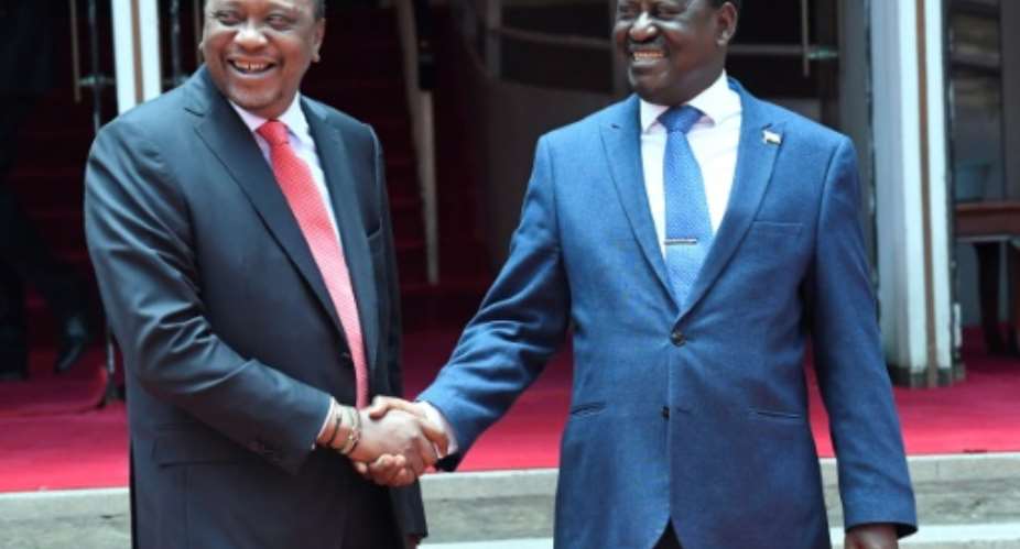 Is this the clinch that changed history? President Kenyatta, left, shakes hands with rival Raila Odinga on March 9.  By SIMON MAINA AFP