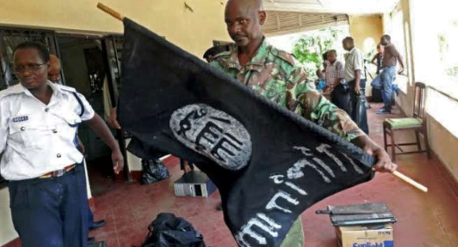 A Kenyan police officer folds up a flag inscribed with the logo of the Islamic state IS following a raid on two mosques in the coastal city of Mombasa.  By  AFPFile