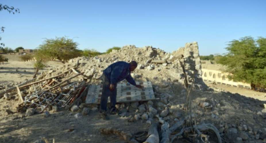 A man checks on January 29, 2013 the ruins of the mausoleum of Alfa Moya, a Muslim saint, which was destroyed by Islamists in July, in a cemetery of Timbuktu, Mali.  By Eric Feferberg AFPFile