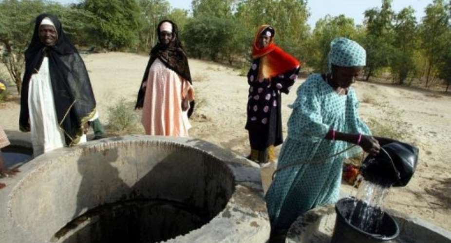 Women gather water to water vegetables in their garden near Timbuktu in 2002.  By Georges Gobet (AFP/File)