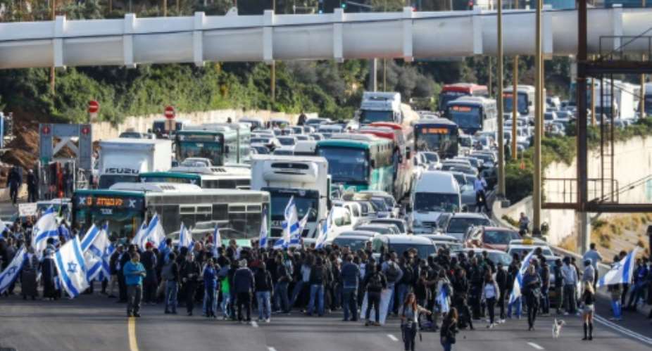 Israelis of Ethiopian origin block Tel Aviv highway as they protest against police violence and racism after an officer shot a young community member dead.  By JACK GUEZ AFP