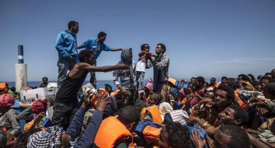 In this handout picture taken on May 3, 2015 and released by MOAS Migrant Offshore Aid Station, migrants wait on a wooden boat during a rescue operation in partnership with Doctors Without Borders off the coast of Sicily.  By Jason Florio MOASAFP