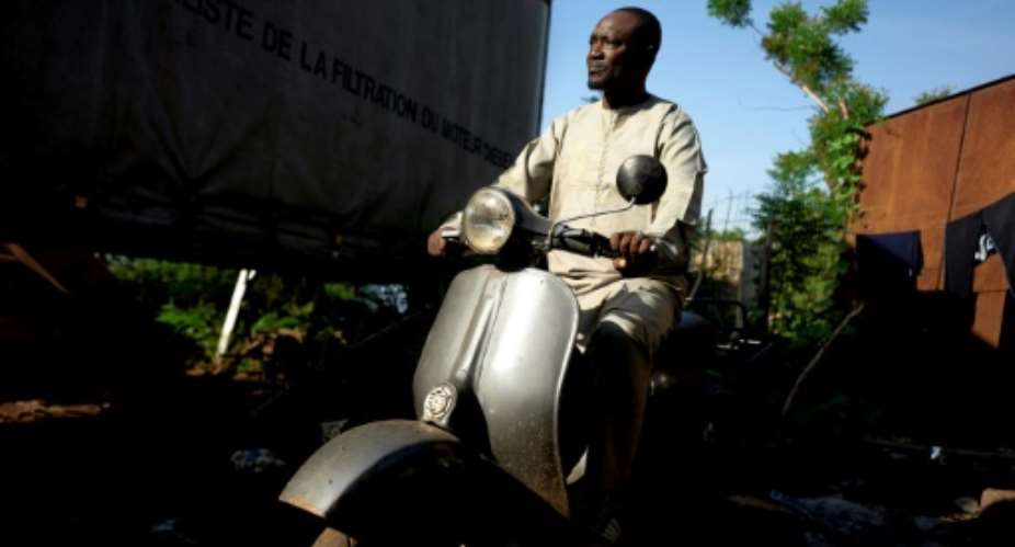 It's love: Seydou Seck and his cherished Vespa.  By MICHELE CATTANI AFP