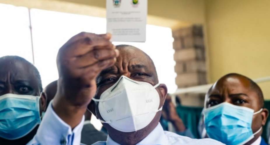 I've been jabbed: Vice President Constantino Chiwenga, who is also health minister, holds up his vaccination certificate.  By Jekesai NJIKIZANA AFP