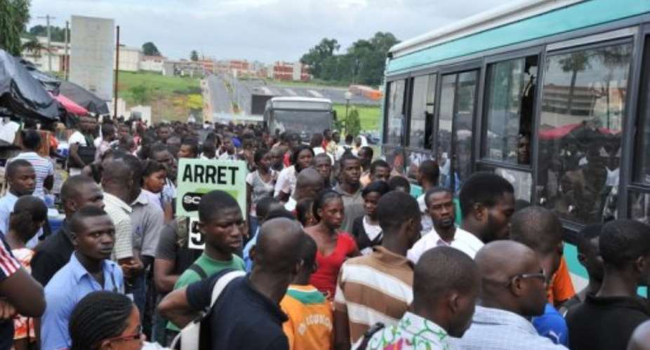 Students waiting at a bus stop after classes at Felix Houphouet-Boigny University in Abidjan on May 16, 2013.  By Issouf Sanogo (AFP/File)
