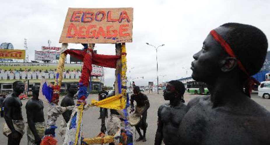 Members of the artist group 'Be Kok Spirit''  hold a placard reading Ebola, go away as they march to raise awareness on the Ebola virus, on August 19, 2014 in Abidjian.  By Sia Kambou AFP