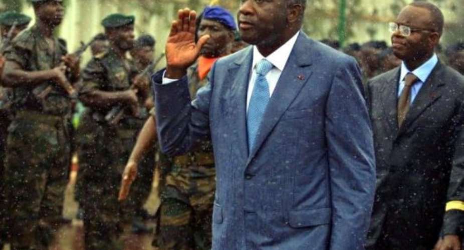 Ivory Coast s President Laurent Gbagbo (C) salutes followed by Defence minister Moise Lida Kouassi in 2001.  By Issouf Sanogo (AFP/File)