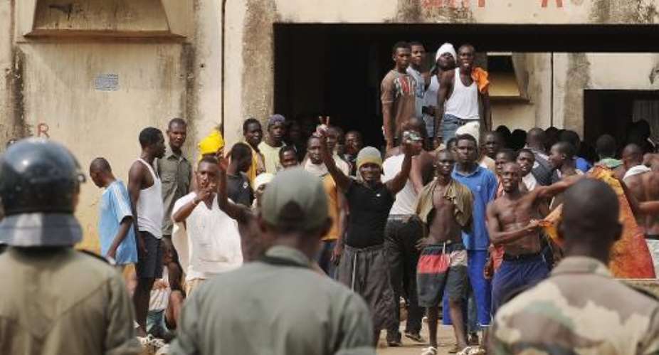 Police stand in front of prisoners who left their cells in Abidjan's prison on December 13, 2008.  By Kambou Sia AFPFile