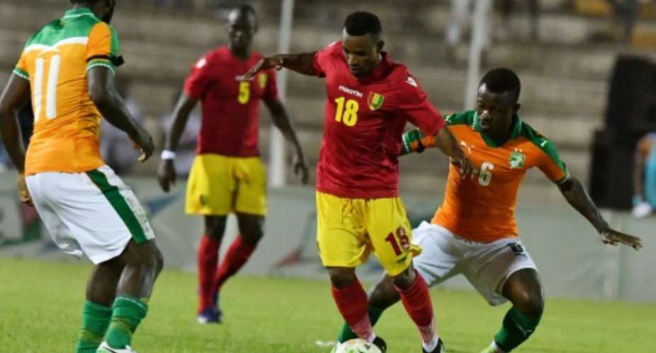 Ivory Coast's Jean Michael Seri R and Franck Kessie L fight for the ball with Guinea's Seydouba Soumah C  during the 2019 Africa Cup of Nations qualifying football match June 10, 2017.  By ISSOUF SANOGO AFP