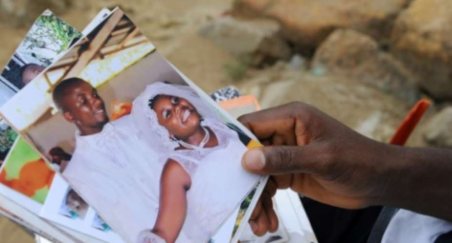 James Harris with photographs of his wife, Salome Karwah. He says nurses refused to touch her because she was an Ebola survivor.  By Zoom DOSSO AFP