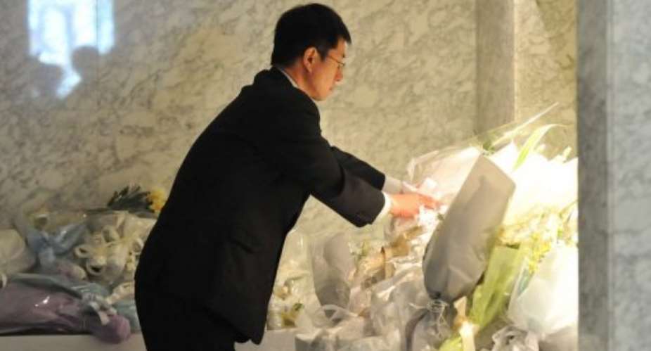 A man offers flowers for Japanese victims of the Algerian hostage crisis in Yokohama, suburban Tokyo on January 24, 2013.  By Kazuhiro Nogi AFP