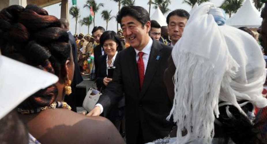 Japanese Prime Minister Shinzo Abe is welcomed by local chiefs on January 10, 2014 at the Felix Houphouet-Boigny international airport in Abidjan.  By Issouf Sanogo AFP