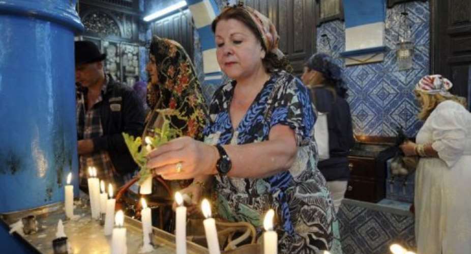 A French Jewish woman lights a candle at the Ghriba synagogue in Djerba.  By Fethi Belaid (AFP)