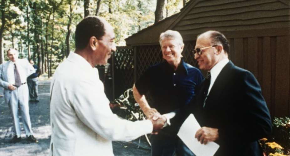 Jimmy Carter with Egypt's Anwar Sadat left and Israel's Menachem Begin right on September 6, 1978 at Camp David.  By  FILESCONSOLIDATED NEWS PICTURESAFPFile