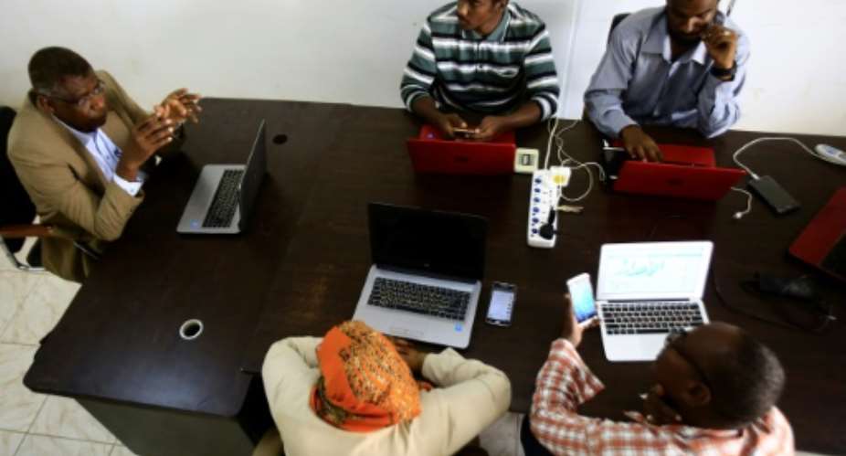 Journalists attend a meeting with Adil al-Baz L, editor of online newspaper Al-Ahdath News, at his office in downtown Khartoum.  By ASHRAF SHAZLY AFP