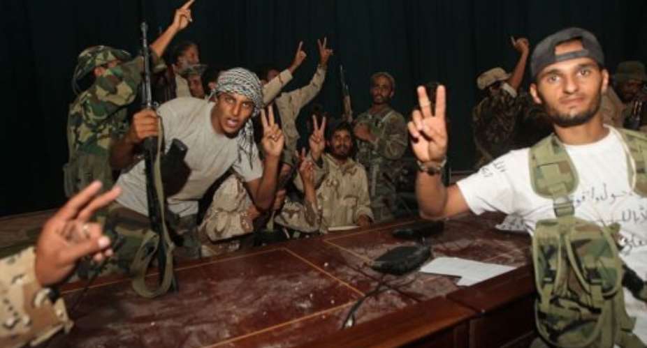 NTC fighters make victory signs at the meeting hall of the Ouagadougou conference centre.  By Ahmad al-Rubaye (AFP/File)
