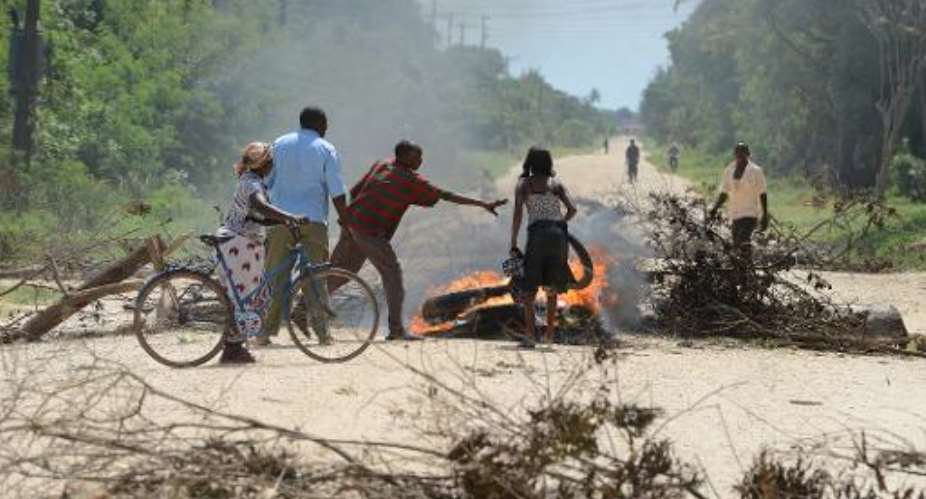 Locals block the road with a barricade as they protest the rising insecurity following the killings in Mpeketoni on June 17, 2014.  By Simon Maina (AFP/File)