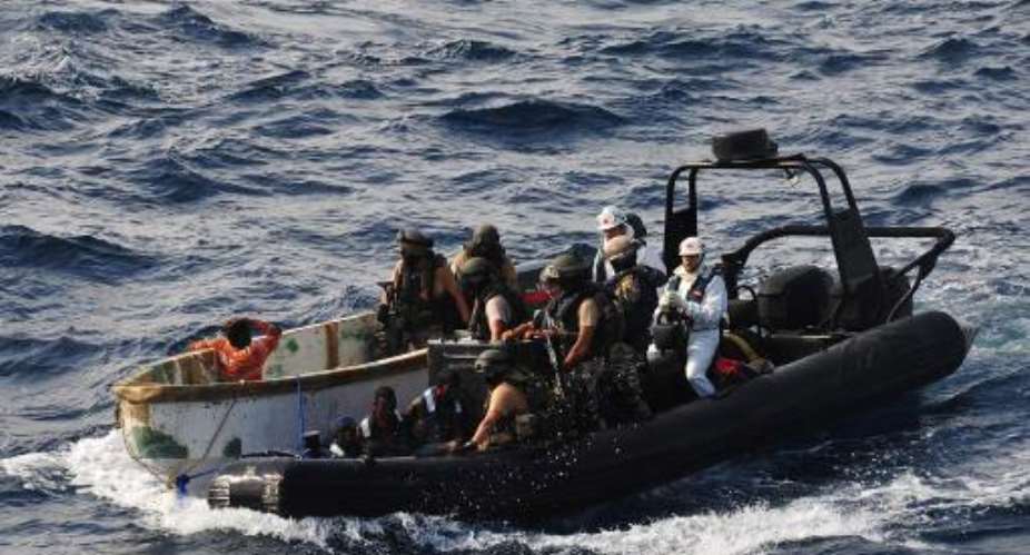 This handout picture released by the EU Navfor on January 13, 2012 shows members of the ESPS Patino escorting suspected pirates to their ship.  By  EU NAVFORAFPFile