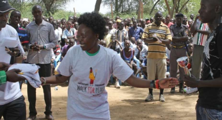 Picture released by Aegis Trust on July 14, 2015 shows former New York marathon champion Tegla Loroupe C handing out a trophy and 'Walk-for-Peace' merchandise to a participant.  By HO AEGIS TRUSTAFPFile