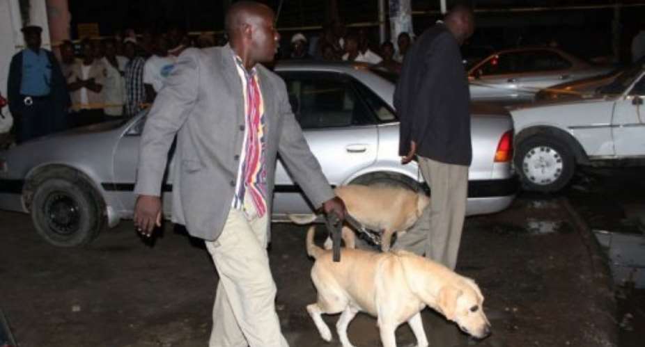 Kenyan police officers arrive with sniffer dogs at the scene of a grenade attack in Mombasa.  By Michael Richard AFPFile