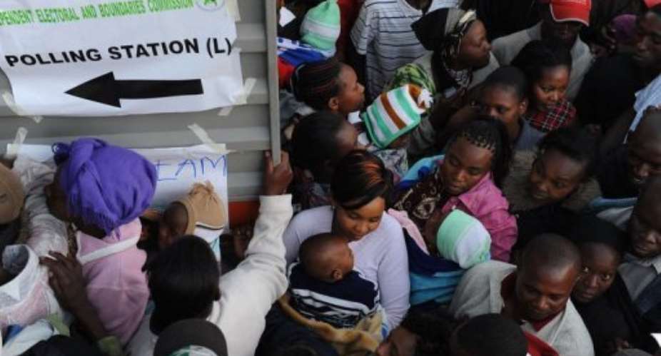 Kenyans in the Dandora neighborhood of Nairobi wait to vote on March 4, 2013.  By Jennifer Huxta (AFP)