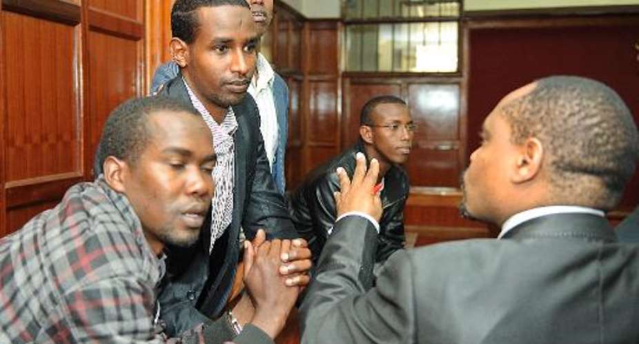 L-R: Omar Liban Adulle, Mohamed Abdi Ahmed, Hussein Hassan Mustafa and Adan Mohammed Abdikadir talk with their lawyer Mbugua Muriithi at the Nairobi High Court on August 20, 2014.  By Tony Karumba AFP