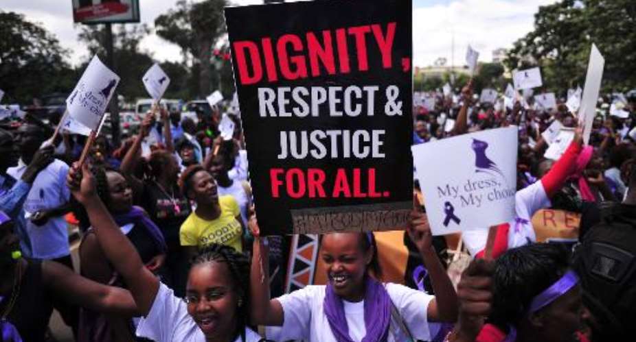 Women hold up placards and shout slogans during a rally against violence to women in Nairobi on November 17, 2014.  By Simon Maina AFP