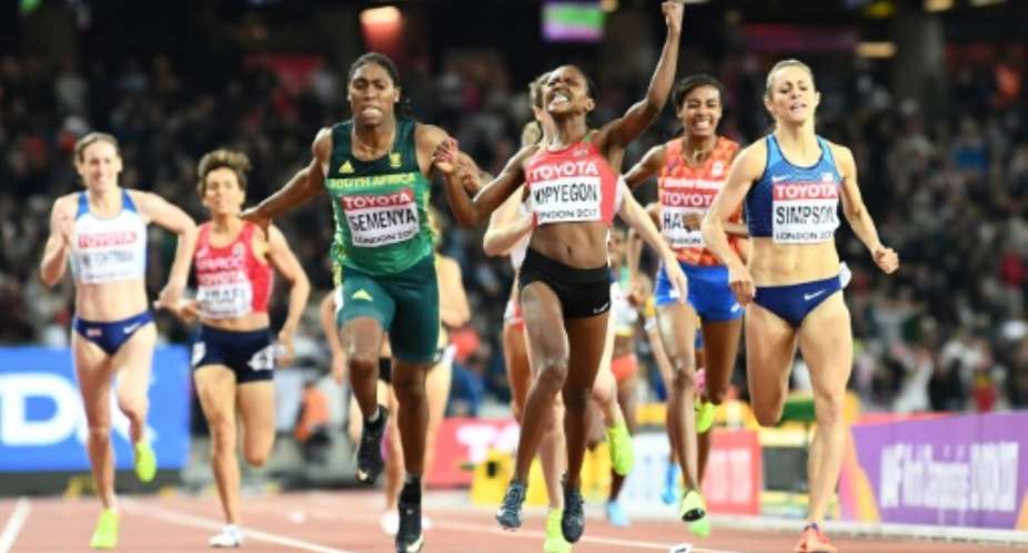 Kenya's Faith Chepngetich Kipyegon celebrates winning as South Africa's Caster Semenya grabs third in the final of the 1,500m event, at the 2017 IAAF World Championships in London on August 7.  By Jewel SAMAD AFP