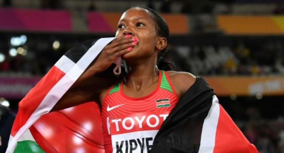 Kenya's Faith Kipyegon celebrates after winning the final of the women's 1,500m at the 2017 IAAF World Championships in London on August 7, 2017.  By Ben STANSALL AFP