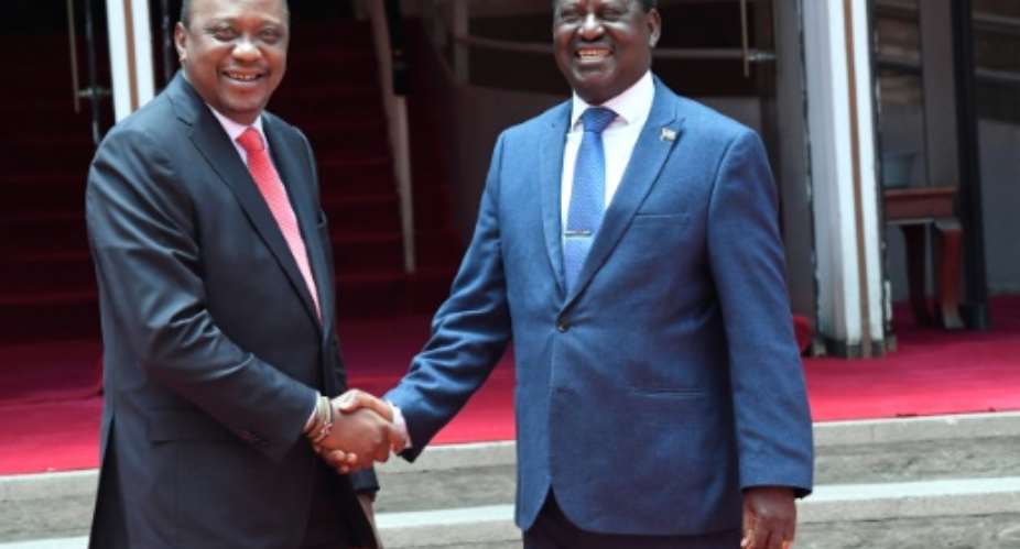 Kenya's President Uhuru Kenyatta shakes hands with opposition leader Raila Odinga as the pair met for the first time in public since last year's disputed elections.  By SIMON MAINA AFP