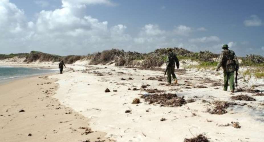 Armed police men patrol a stretch of beach near Kiwayu Safari village on September 12.  By William Davies (AFP/File)