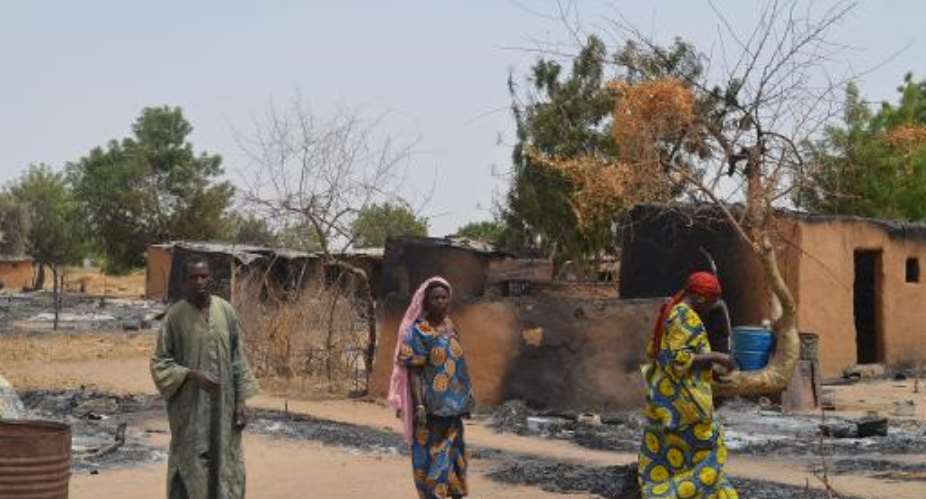 Villagers walk through razed homes in Mainok, outside Maiduguri, Borno State, Nigeria, on March 6, 2014.  By Str AFP