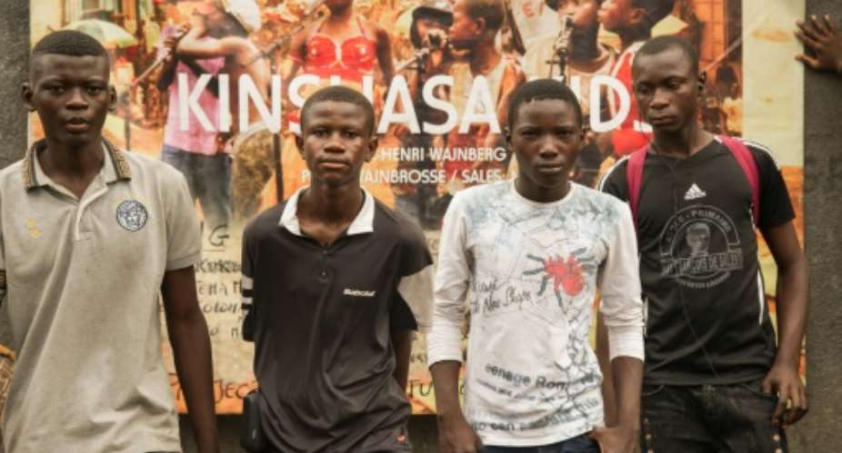 Boys pose in front of a poster for the film Kinshasa Kids at the Lycee Molende in Matete, in the Mont Amba district of Kinshasa, on September 24, 2015.  By Junior Kannah (AFP/File)