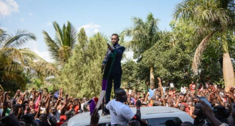 Kyagulanyi addressed cheering supporters outside his home as the police looked on.  By Isaac Kasamani AFP