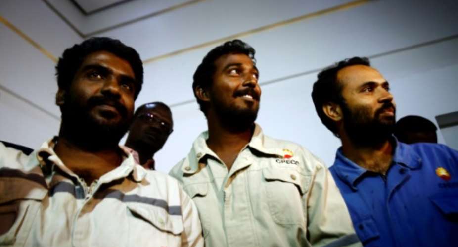 L to R Indians Midhun Ganesh and Edward Ambrose and Pakistani Ayaz Hussein Jamali, look on upon their arrival at Khartoum airport on March 30, 2017.  By ASHRAF SHAZLY AFP