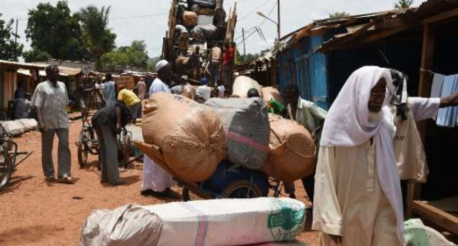 A group of Central African Muslims, who had been waiting for three months for a possible escort, gather their belongings from a truck after decicing they would stay in the PK5 district of Bangui on April 23, 2014.  By Issouf Sanogo AFP