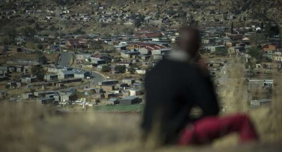 A man sits on a hill overlooking Maseru, Lesotho, on August 31, 2014.  By Mujahid Safodien AFP