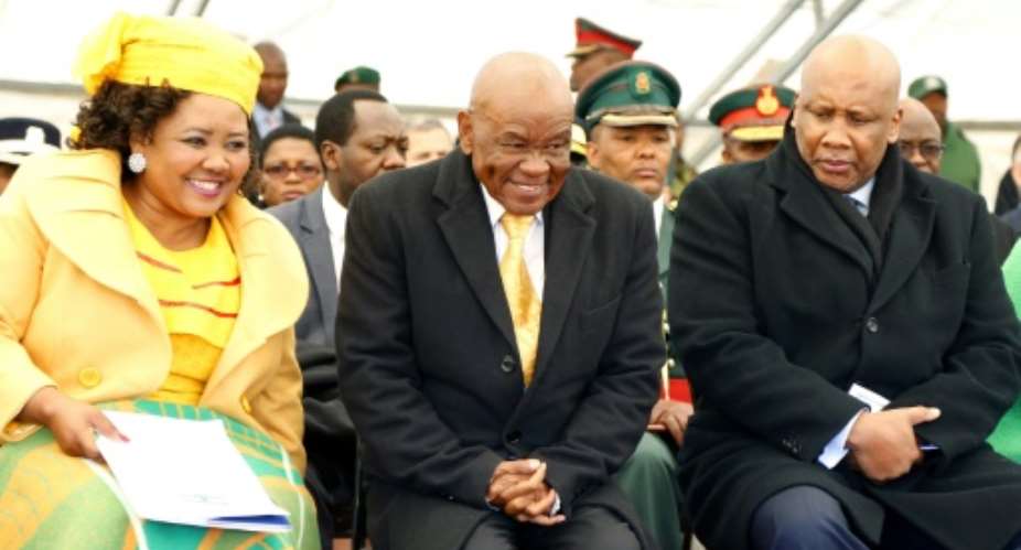 Lesotho Premier Thomas Thabane C, pictured here with the country's King Letsie III R, is facing criticism over the role of his wife Maesaiah L.  By SAMSON MOTIKOE AFPFile