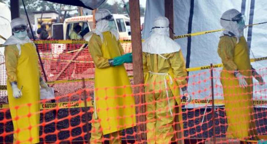 A picture taken on August 21, 2014 shows  international NGO Medecins Sans Frontieres MSF - Doctors Without Borders staff members standing wearing protective gear at the MSF ELWA hospital in Monrovia.  By Zoom Dosso AFPFile