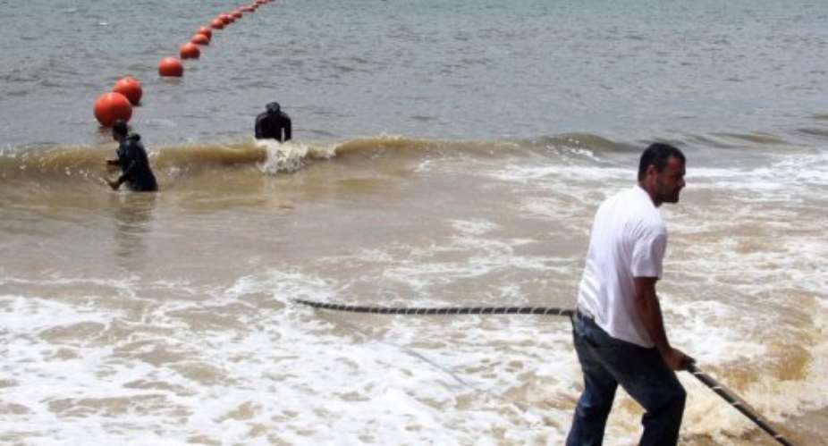 Technicians display the ACE submarine fiber optic cable on the shore of Libreville, Gabon, in 2011.  By  (AFP/File)