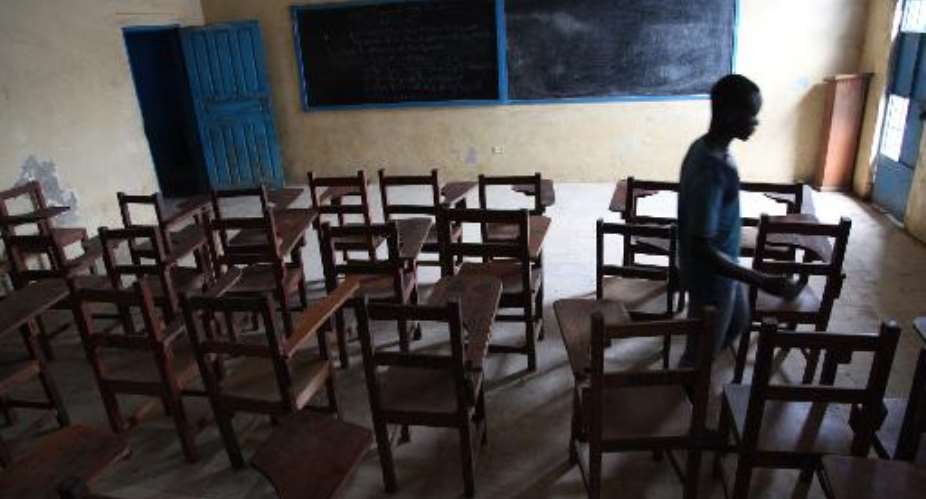 A boy walks on July 31, 2014 through an empty class room in a school in Monrovia which has been closed down by the Liberian government to protect students from contracting Ebola.  By  AFP