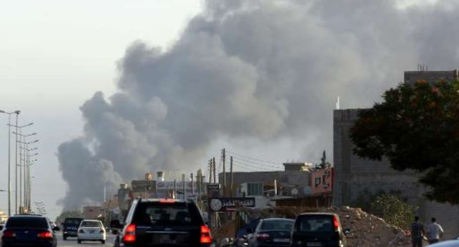 Smoke billows from an area near Tripoli's international airport as fighting between rival factions around the capital's airport continues on July 24, 2014.  By Mahmud Turkia AFPFile