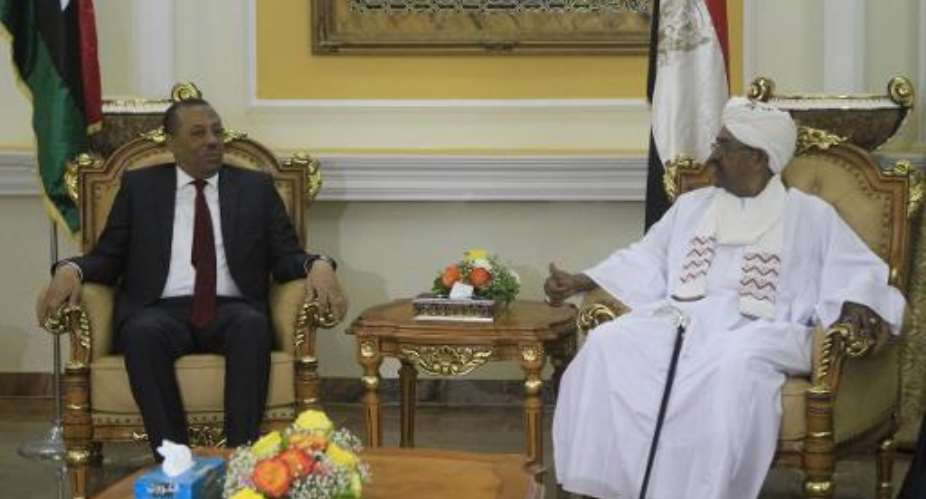 Abdullah al-Thani left meets Sudanese President Omar al-Bashir at the presidential palace in Khartoum on October 28, 2014.  By Ashraf Shazly AFP